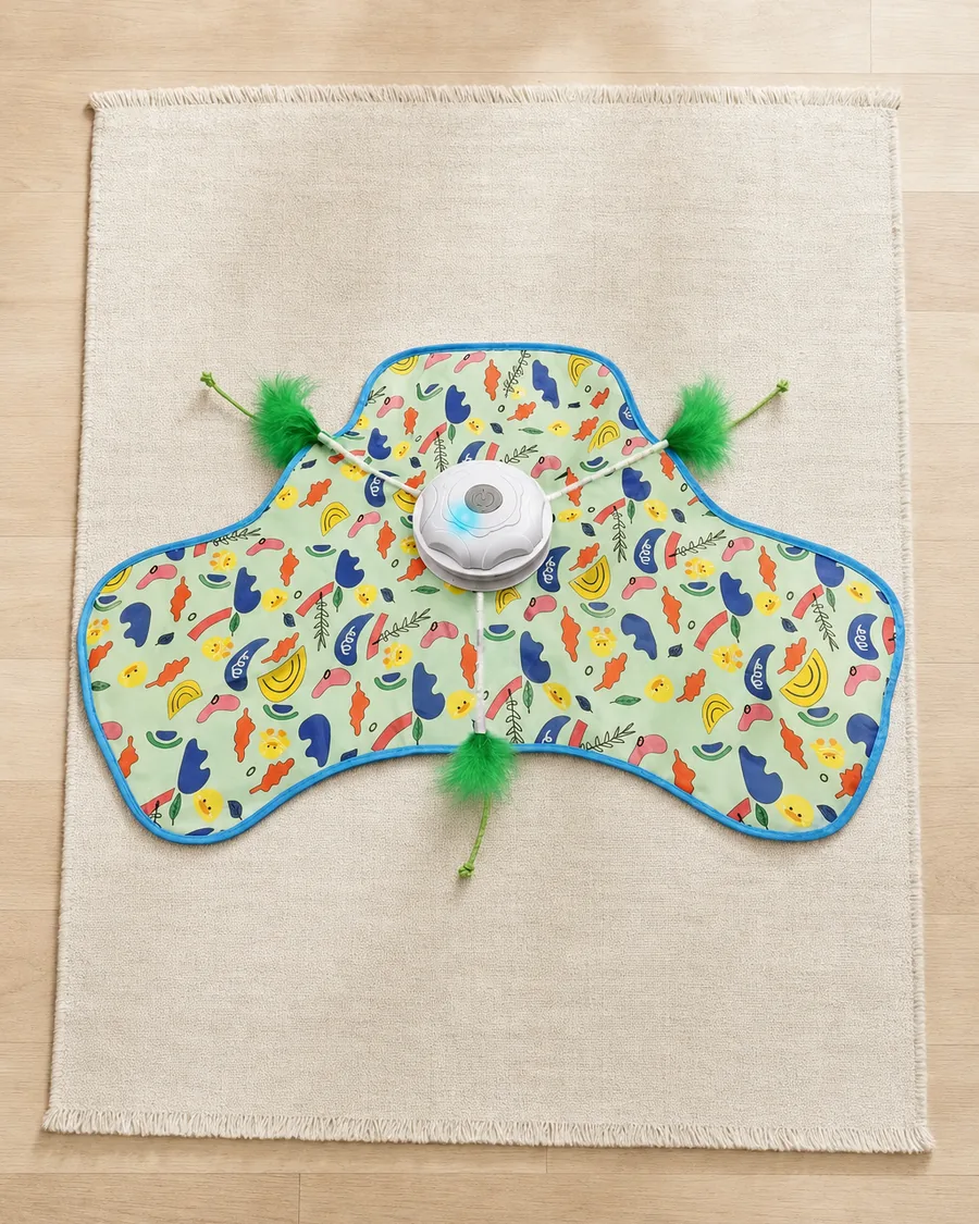 Feather play mat with its motorised teaser, seen from above on a rug